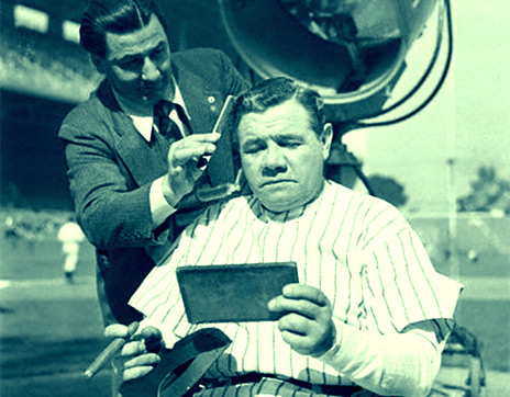Babe Ruth Receiving Makeup for Movie Shoot. Original caption: Reel life with the Sultan of Swat...With a big, black cigar in his hand and a $25,000 check in his pocket, Babe Ruth, former home run king, doesnt mind the paint and powder as the studio makeup man checks makeup for the Bambinos role in the movie depicting life of Larrupin Lou Gehrig, late famed first baseman for the Yankees. Feb 13, 1942